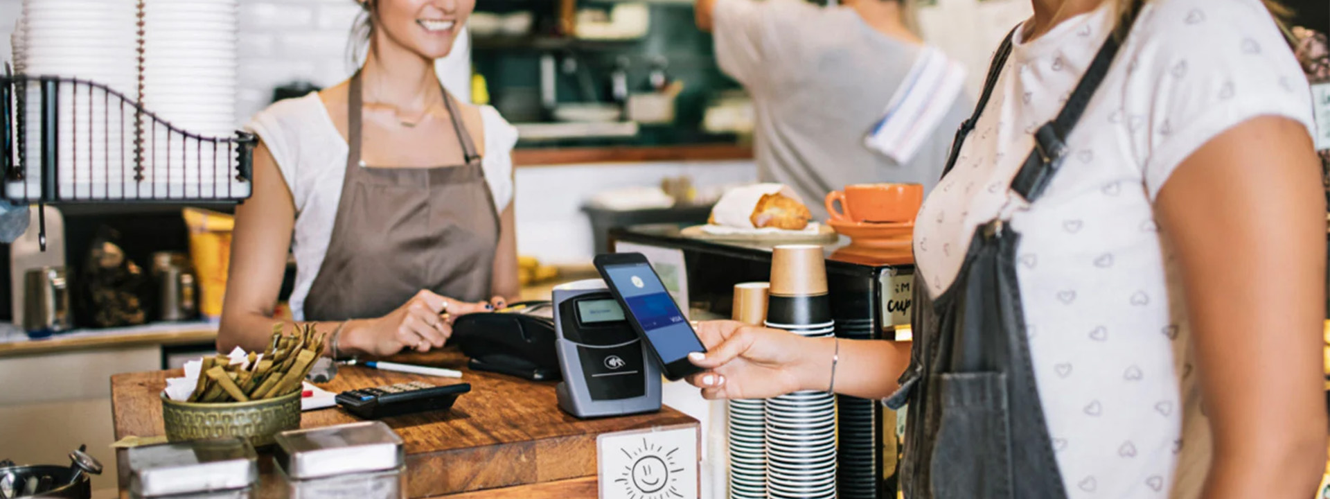 woman paying with contactless in coffee shop