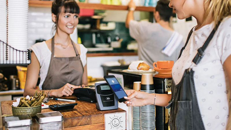 woman paying with contactless in coffee shop