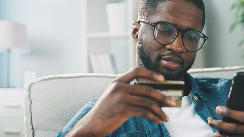 man inputting card details into mobile phone